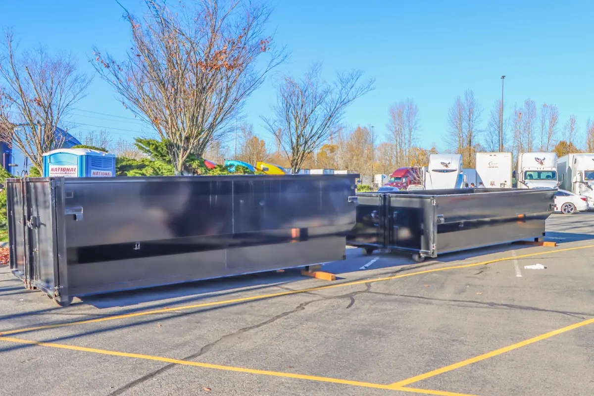 Professional dumpster rental service with roll-off container on residential driveway in Westbury